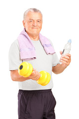 A mature man exercising with a dumbbell and holding a bottle of