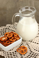 Tasty pretzels in white bowl and milk jug
