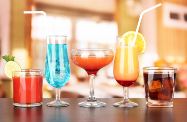 Several glasses of different drinks on bright background