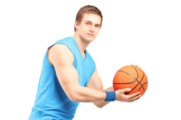 A male basketball player with basketball looking at camera