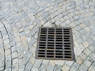 sewer cover at paved stone