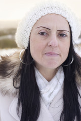 worried woman in snow covered fields at sunset