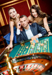 Man accompanied by woman placing bets at the casino