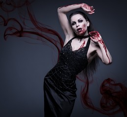 Beautiful vampire woman covered in blood