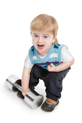 Small boy is trying to raise large dumbbell