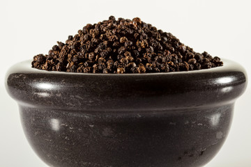 Fototapeta na wymiar Black peppers in a clay pot
