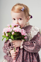 beautiful little girl in retro dress with bouquet of flowers