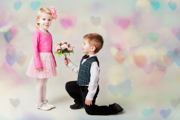 Little boy giving flowers to girl