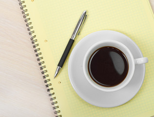 Coffee cup with note book on table