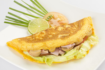 Omelette stuffed with vegetables on white plate