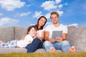 family in nature with tablet