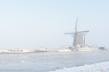 Frozen Canal and Windmill in the Mist