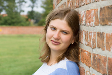 Woman against a brick wall