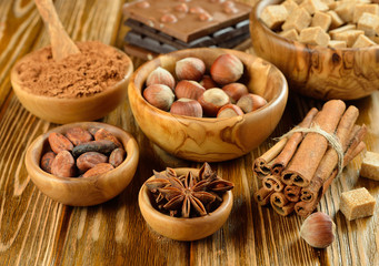Fototapeta na wymiar Nuts, spices and cocoa in a wooden bowl on a brown table