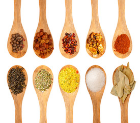 wooden spoons with seasonings on a white background