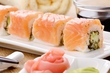 Philadelphia roll sushi on a white plate with soy sauce wasabi a