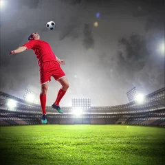 Foto op Plexiglas voetballer die de bal slaat © Sergey Nivens