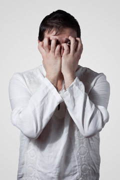 Young man hiding his face with hands