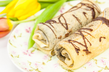 crepes or pancakes with chocolate sauce and sugar powder