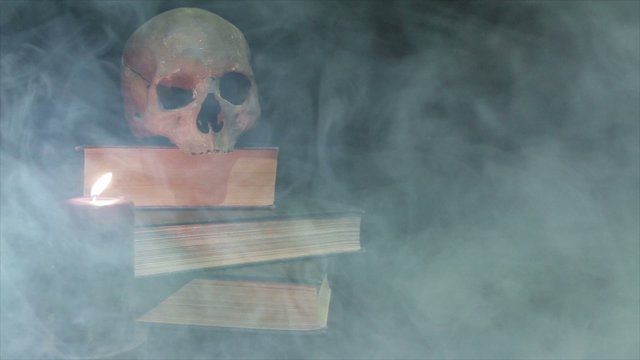 Human skull and voodoo doll in the smoke