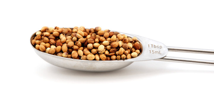 Coriander/cilantro seeds measured in a metal tablespoon