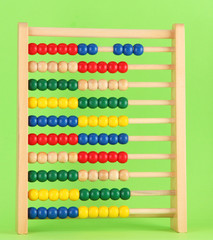 Bright wooden toy abacus, on green background