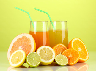 Lots ripe citrus with juices on green background