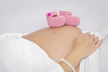 Babybauch mit Babyschuhen