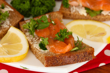 Salmon sandwich on plate,on wooden background, close up