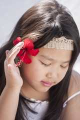 Naklejka premium Cute little girl with hibiscus flower