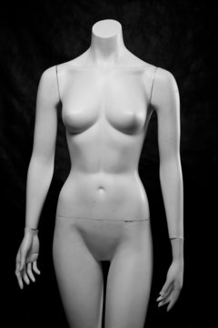 Old female fashion mannequin on a black background