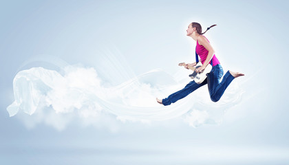 young woman playing on electro guitar and jumping