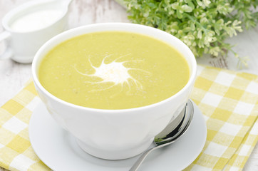 bowl of green pea soup with ginger and cream horizontal