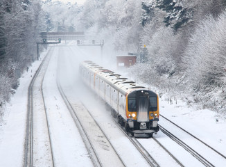 commuter train travelling in snow - Powered by Adobe