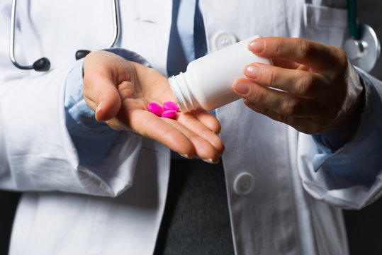 Closeup on medical doctor woman empty medicine bottle in hand