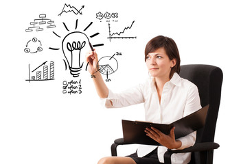 Young business woman drawing light bulb with various diagrams an