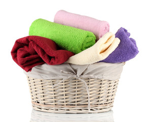 Colorful towels in basket isolated on white