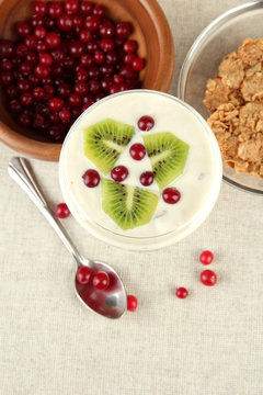 Glass of yoghurt dessert with fruits and berries,