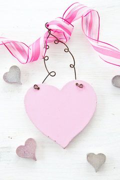 White wooden background with pink heart