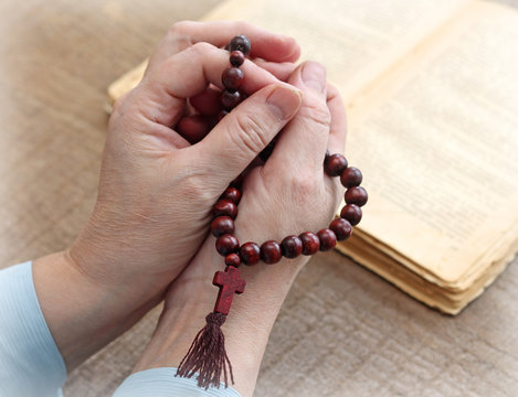 Woman's hands holding rosary, close-up