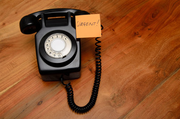 Black retro telephone with reminder note