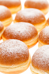 Viele Krapfen mit Staubzucker nebeneinander