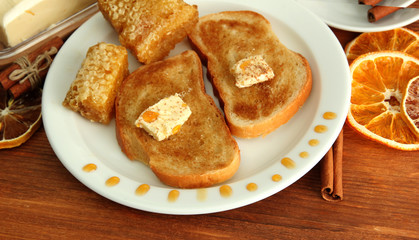 White bread toast with honey and cup of coffee on wooden table