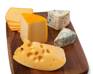 Different types of cheese on wooden board