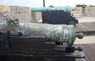 Old canons lined up in front of the bay aiming at the sea