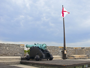 Old canon aiming at the sea, on an overcast day.