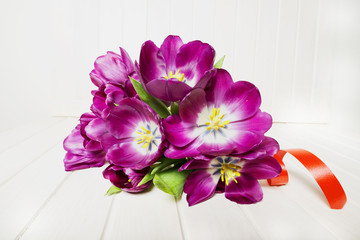 bunch of purple tulips on a white table