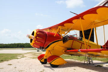 Fototapeta premium Colorful vintage airplane by a hanger