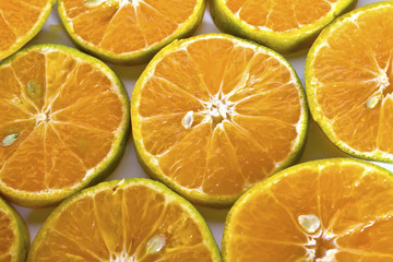 A glass of orange juice and sliced oranges on white background w
