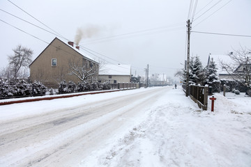 Wieś pokryta śniegiem w pochmurny dzień.